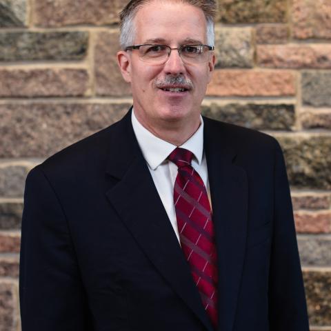 Rev. Dr. Curtiss Paul DeYoung MCC CEO Rev. Dr. Curtiss Paul DeYoung stands in front of a stone wall